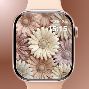 Puede incluir: Un reloj inteligente de oro rosa con una pantalla floral. La pantalla muestra un patrón de margaritas crema, rosa y malva. La hora es 15:15 el viernes 24.
