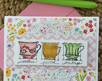 May include: A set of three ceramic mugs with a speckled, matte finish. The mugs are in shades of cream, light gray, and dark gray. Each mug has a simple, minimalist design, perfect for coffee or tea.