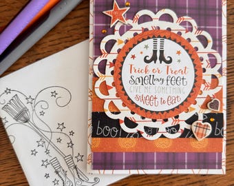 May include: A handmade Halloween greeting card featuring a purple plaid background, a white scalloped paper doily, and a circular center with the text Trick or Treat smell my feet GIVE ME SOMETHING sweet to eat. Includes a matching envelope with a broom and boots illustration.
