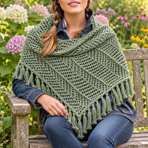Peut inclure: Un châle triangulaire en crochet vert sauge présentant un motif géométrique ajouré complexe et des franges décoratives le long des bords inférieurs. Le châle est drapé sur les épaules, mettant en valeur la texture du fil.