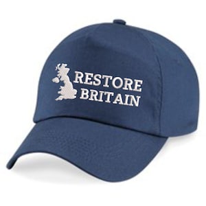 May include: A navy blue baseball cap featuring the text "RESTORE BRITAIN" in white, alongside a white outline of the UK. The cap has a curved peak and a button on the crown, a classic design.