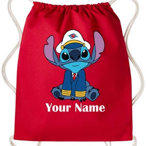 Op de afbeelding: Rode rugzak met trekkoord met een stripfiguur met een kapiteinshoed en uniform. Het personage is blauw met grote oren en ogen. De tekst "Your Name" staat in het wit op de bodem van de tas.