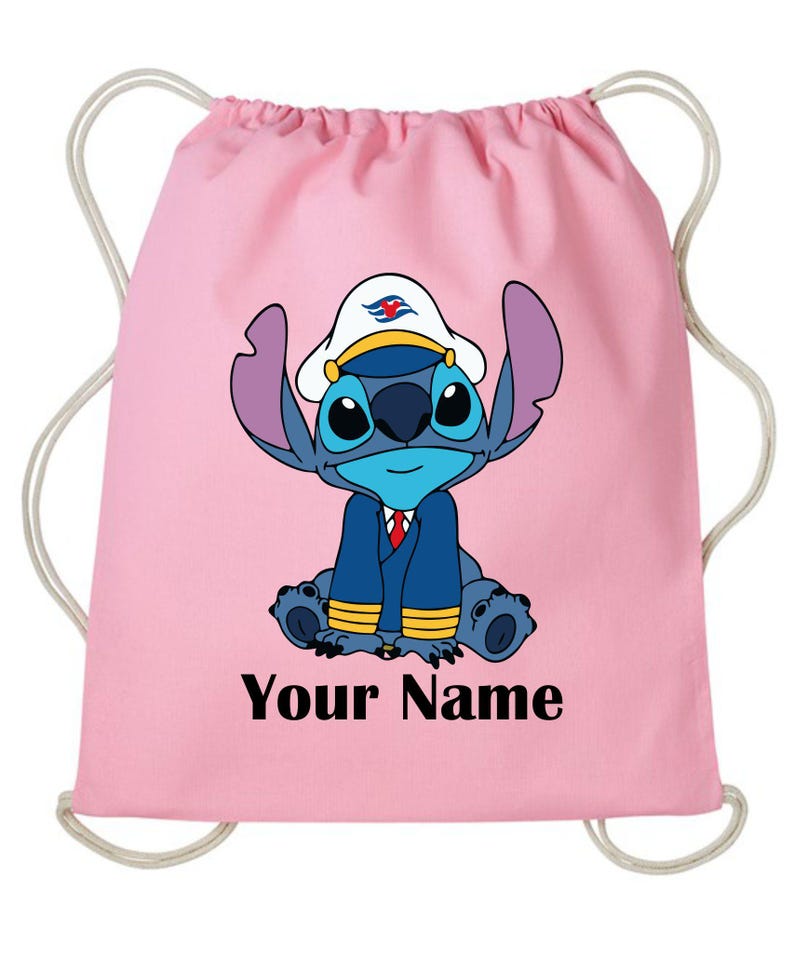 Op de afbeelding: Roze trekkoordtas met een blauw stripfiguur met een witte kapiteinshoed en een marineblauwe jas. De tekst "Your Name" is in het zwart onderaan gedrukt. De tas heeft witte trekkoorden.