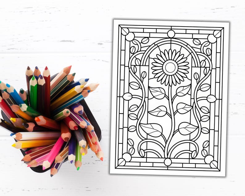 May include: A black container filled with a variety of colored pencils next to a black and white line drawing of a sunflower. The sunflower drawing is in a stained glass style with a floral design.