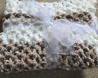 Manta de bebé tejida a crochet gruesa, con motas marrones, beige y blancas.