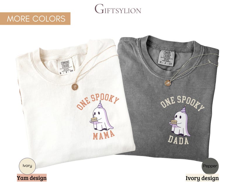 May include: Two short-sleeve crew neck t-shirts in ivory and pepper gray. Each shirt features a graphic of a ghost wearing a party hat and holding a cake. The ivory shirt has the text ONE SPOOKY MAMA, and the pepper gray shirt has the text ONE SPOOKY DADA.
