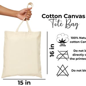 May include: A plain off-white cotton canvas tote bag with two handles. Text reads: Cotton Canvas Tote Bag, 100% Natural cotton Canvas, 100% COTTON, Do not iron directly over the printed area, Do not bleach. Dimensions are 16 inches by 15 inches.
