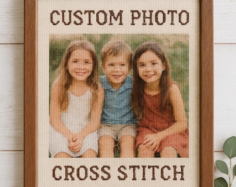 Peut inclure: Une broderie au point de croix encadrée avec une photo personnalisée de trois enfants souriants. Les mots "CUSTOM PHOTO" et "CROSS STITCH" sont brodés en fil marron. Le cadre est en bois.