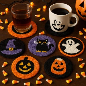 Op de afbeelding: Een verzameling Halloween-onderzetters met verschillende ontwerpen, waaronder een heksenhoed, een zwarte kat, een spook en pompoenen. De onderzetters zijn in oranje, zwart en paars, met een getextureerde, geluste uitstraling. Een glas vloeistof en een mok met een spookontwerp zijn ook aanwezig.