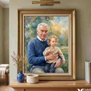 Puede incluir: Un retrato enmarcado de un hombre sosteniendo a un niño pequeño. El hombre lleva un suéter azul y el niño un suéter beige. El retrato está en un marco dorado y se exhibe sobre una superficie de madera. Un jarrón azul y una cesta tejida están delante.