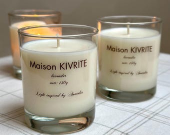 May include: Three glass candles with white wax and wicks are displayed. The candles have the text "Maison KIVRITE" and "lavender" printed on them, with a net weight of 150g. The phrase "Light inspired by Anatolia" is also visible.