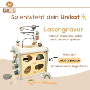 May include: Wooden activity cube with a bead maze, animal shapes, and a hammer toy. The cube is light green and natural wood, with the text "KidsLino" and "So entsteht dein Unikat". Includes the text "Lasergravur".