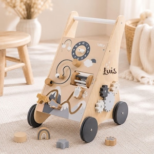May include: Wooden baby walker with interactive features like a clock, bead maze, and gears. The walker has a natural wood finish with neutral-toned painted details. The name "Luis" is written on the side. Includes wooden shapes. Measures approximately 50cm in height.