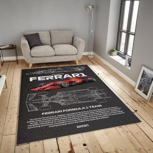 May include: Black rectangular area rug featuring a red and black Ferrari Formula 1 race car design. The rug includes the text "FERRARI FORMULA 1 TEAM" and technical drawings of the car. The rug is placed on a hardwood floor.