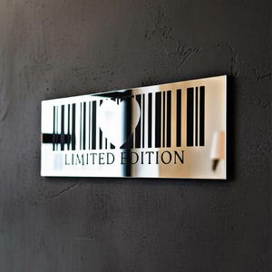 May include: A rectangular, mirrored wall art piece with a barcode design. A heart shape is cut out of the barcode, and the words "LIMITED EDITION" are printed below. The art is mounted on a dark gray textured wall.