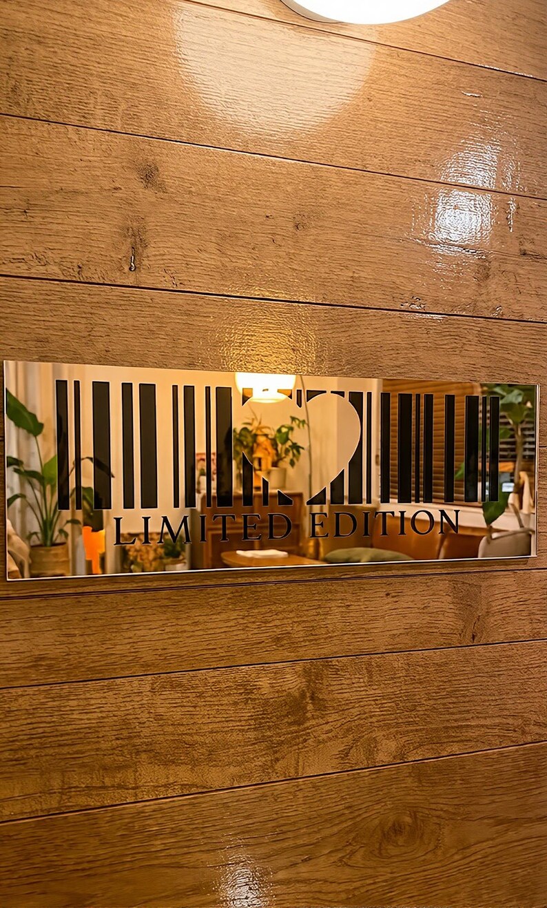 May include: A rectangular mirror with a barcode design and the words "LIMITED EDITION" in black. The mirror is mounted on a wooden wall. The barcode design includes a heart shape.