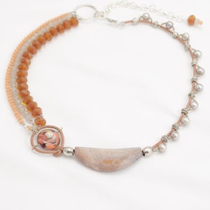 May include: A multi-strand necklace featuring brown and beige beads, a silver and brown leather cord, and a silver and grey agate pendant.