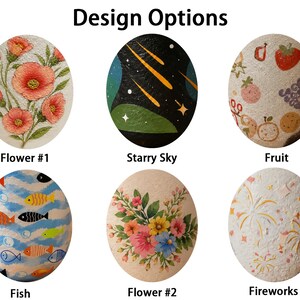 May include: Six oval-shaped items featuring distinct designs labeled Design Options: Flower #1 with pink flowers, Starry Sky with yellow comets on black, Fruit with colorful produce, Fish with blue waves, Flower #2 with a floral bouquet, and Fireworks with gold bursts.