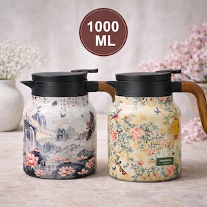 May include: Two decorative 1000 ml insulated carafes with black lids and wooden handles. One features a landscape design with pink lotus flowers, the other a floral pattern with butterflies and birds. The carafes are designed for hot or cold beverages.