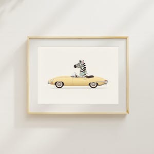 May include: A framed art print featuring a yellow convertible car with a zebra driver. The zebra is wearing a scarf and driving the car. The artwork has a minimalist style and is set against a white background.