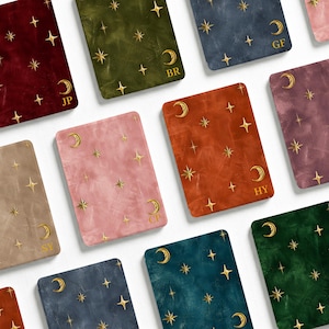 May include: A collection of rectangular covers in various solid colours including red, olive green, blue, pink, orange, purple, beige, and dark green. Each cover features a gold foil pattern of stars and crescent moons, with two-letter initials.
