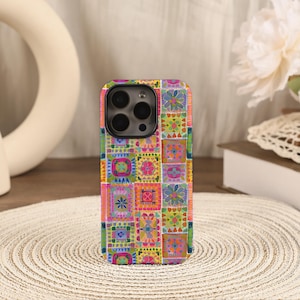 May include: A colorful phone case with a patchwork design. The case features a vibrant mix of squares with floral and geometric patterns in shades of pink, green, yellow, and blue. The case has a glossy finish and a camera cutout.