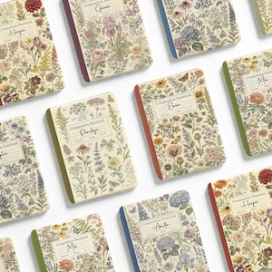 May include: A collection of composition notebooks featuring vintage-style botanical illustrations of various flowers and butterflies. Each notebook has a white label on the front with the text Composition Notebook and a name written in cursive script.