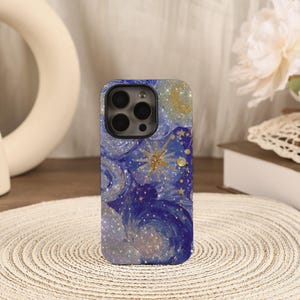 Puede incluir: Una funda para smartphone con un diseño de cielo nocturno en espiral azul oscuro y morado con detalles de purpurina dorada, que incluye una estrella dorada prominente, estrellas más pequeñas y una luna creciente. Tiene un recorte negro.