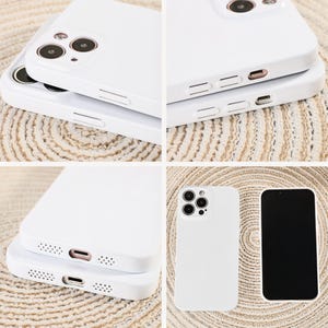 May include: White phone cases with camera cutouts and button details are stacked and displayed. One case is shown next to a phone with a black screen. The cases are made of a smooth, solid material.