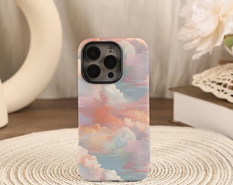 Könnte beinhalten: Smartphone-Hülle mit einem pastellfarbenen Wolkenmuster in Rosa, Orange und Blau. Die Hülle hat eine glänzende Oberfläche und einen Kameraausschnitt. Die Gesamtästhetik ist weich und verträumt.