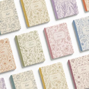 May include: A collection of rectangular composition books featuring various floral line art patterns in shades of pink, blue, green, and yellow. Each notebook has a central label with a name printed in script and the text Composition Book.