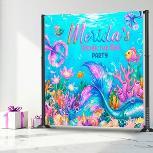 A colorful underwater-themed backdrop with mermaids, fish, coral, and other marine life, along with the text "Merida's Under the Sea Party".