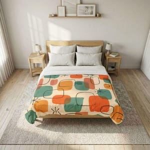 May include: A bed with a cream-colored comforter featuring a mid-century modern design. The pattern includes orange, teal, and coral-colored geometric shapes outlined in black. The bed is made up with white pillows and a wooden headboard.