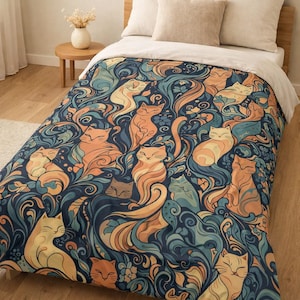 Puede incluir: Una funda nórdica azul marino y blanca con un patrón repetido de gatos estilizados en tonos naranja, amarillo y verde azulado. Los gatos están intercalados con motivos florales y de hojas arremolinadas, creando un diseño caprichoso y artístico.