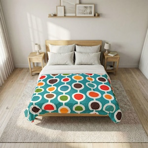 May include: A teal bedspread with a retro design of connected ovals in red, orange, brown, green, and white. The bed is made up with white pillows and a wooden bed frame. The room has light wood floors and a neutral rug.