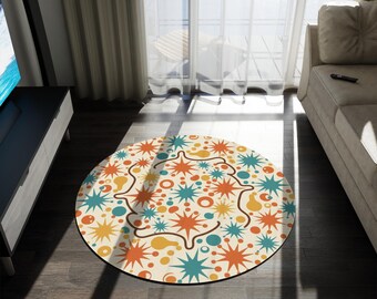 Può includere: Un tappeto rotondo con un design retrò. Il tappeto presenta uno sfondo color crema con esplosioni e forme arancioni, gialle e turchesi. Il tappeto è posato su un pavimento in legno scuro. Il diametro del tappeto è di circa 120 cm.