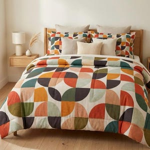 May include: A bed with a wooden headboard and a colorful geometric patterned comforter. The comforter features a design of orange, green, and brown semi-circles. Several pillows in neutral tones complete the bedding set.
