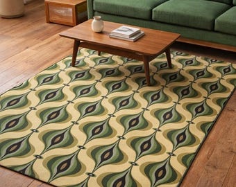May include: A rectangular area rug with a retro design. The rug features a repeating pattern of green, olive, and black teardrop shapes on a cream background. The rug is placed on a hardwood floor, with a green sofa and wooden coffee table in the background.