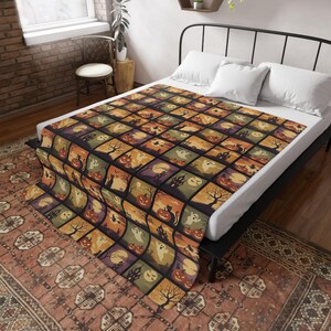 May include: A Halloween blanket with a patchwork design, displaying spooky illustrations. The squares feature pumpkins, ghosts, black cats, and haunted houses in orange, purple, and green. The blanket is on a bed with white pillows.