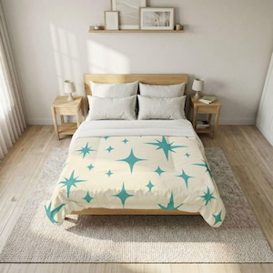 May include: A bed with a cream-colored comforter featuring a teal starburst pattern. The bed has a light wood frame and is made up with white pillows and a white top sheet. The room has light wood floors and a neutral rug.