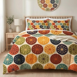 May include: A bed with a colorful comforter set featuring a repeating pattern of large, stylized circles in shades of orange, yellow, green, and blue. The set includes a duvet cover, two pillowcases, and a decorative wall hanging with a matching design.