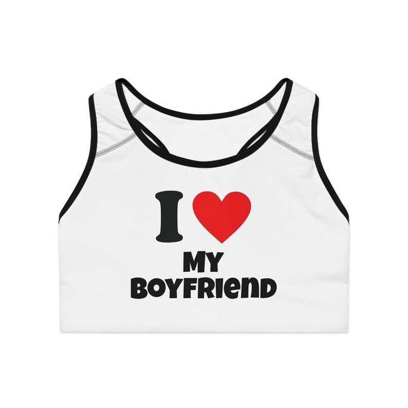 May include: White sports bra with black trim and the text "I ❤️ MY BOYFRIEND" in black and red. The bra has a scoop neck and racerback design.