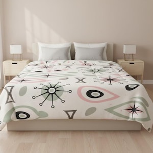 Puede incluir: Una funda nórdica blanca con un diseño moderno de mediados de siglo. Presenta formas geométricas en negro, rosa y gris. El patrón incluye explosiones de estrellas, círculos y formas abstractas, creando una estética retro.