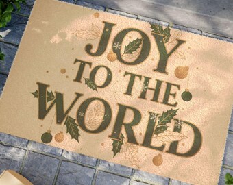 May include: Rectangular tan doormat featuring the phrase "JOY TO THE WORLD" in dark green, adorned with holly, snowflakes, and baubles. The mat rests on a stone surface, ideal for a festive entrance during the holiday season.