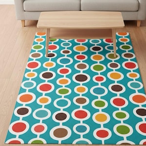 May include: A rectangular area rug with a retro design. The rug features a teal background with a pattern of connected white ovals, each containing a colorful circle in shades of red, orange, yellow, green, and brown. A light wood coffee table sits on top.