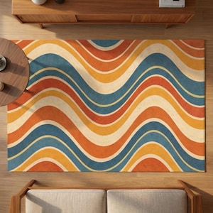 May include: A retro-style area rug with a wavy pattern in shades of blue, orange, yellow, and cream. The rug's design features broad, undulating stripes, creating a vintage aesthetic. The rug is rectangular and appears to be made of a soft material.