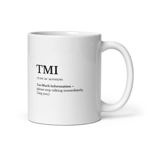 May include: White ceramic mug with the acronym "TMI" printed in black. The text below defines TMI as "Too Much Information - (please stop talking immediately. I beg you.)". The mug has a curved handle.