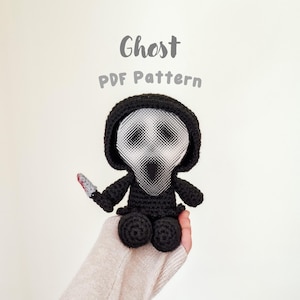 May include: A handmade black crochet Ghost doll with a white mask and a small knife with red accents. The doll is wearing a black hood and has the text "Ghost PDF Pattern" above it.