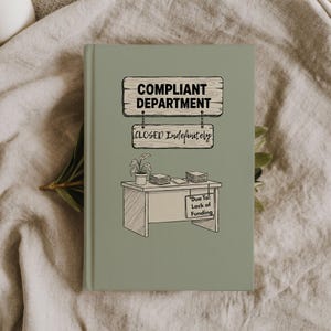 May include: A sage green hardcover journal featuring a black line drawing of a desk with a potted plant and stacks of paper. Hanging signs above the desk read COMPLIANT DEPARTMENT and CLOSED Indefinitely, while a sign on the desk reads Due To: Lack of Funding.
