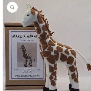May include: A handcrafted giraffe soft toy with brown and white markings is displayed beside a cardboard box. The box has a label that says "MAKE A GIRAF" and "From Sew Crafty Online." The website address www.sewcrafty.online is also visible.